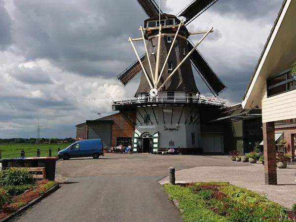 Voorkant van kringloopwinkel in een Nederlandse molen met parkeerplaats