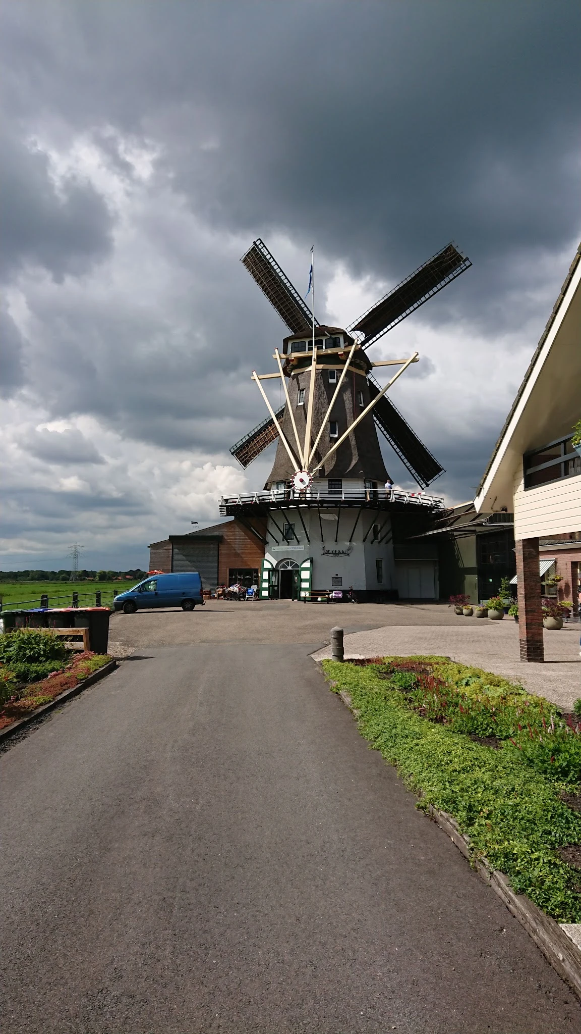 Voorkant van kringloopwinkel in een Nederlandse molen met parkeerplaats