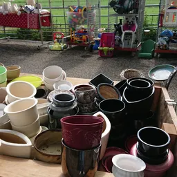 Diverse serviesgoed: witte en zwarte kopjes, kannen en schalen op tafel uitgestald