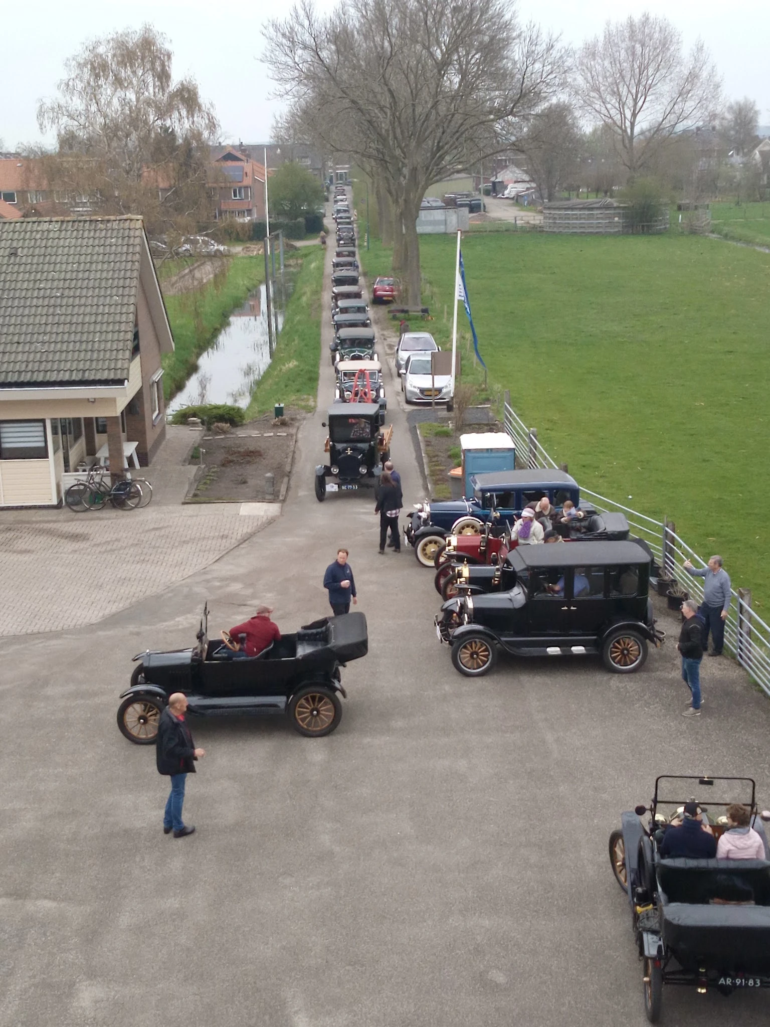 Vintage automobiles verzameld op een erf met toeschouwers