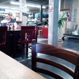 Winkelvloer met houten tafels en stoelen, plantenbak en winkelinterieur op achtergrond