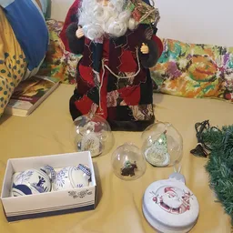 Uitgestalde kerstdecoratie en servies op een gele tafel in de winkel