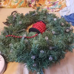 Kerstdecoratie: groene krans versierd met rode kralen en zilveren kerstballen