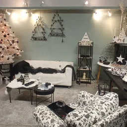 Winkelbinnenkant versierd met kerstdecoratie: witte kerstboom, zitmeubels, kroonluchters en huisraad