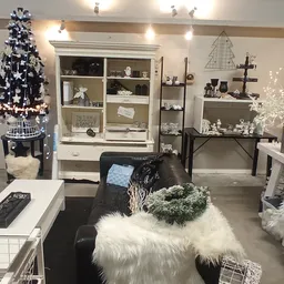 Winkelinterieur met kerstdecoratie, witte bomen, verlichte displays en witte bontmeubilair