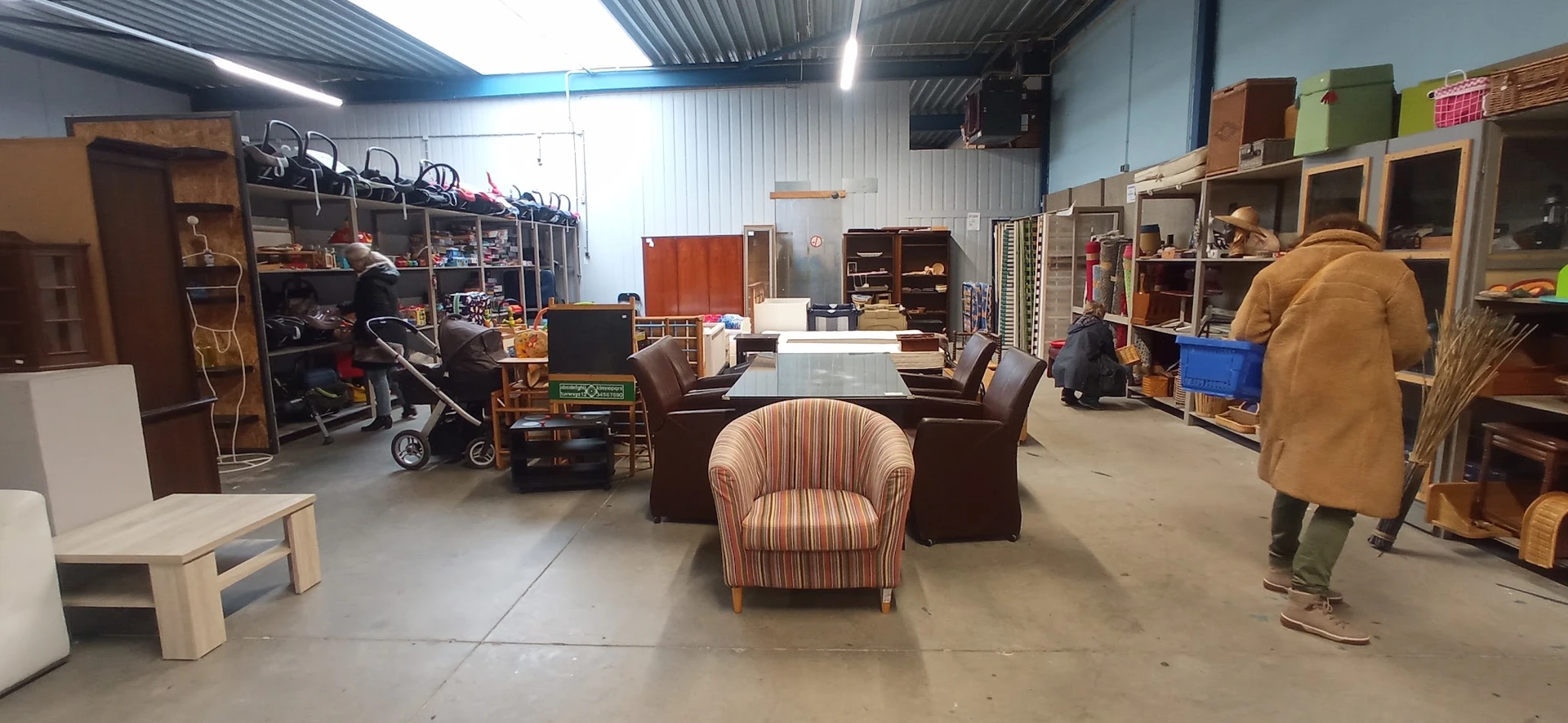 Winkelvloer van kringloopwinkel met meubels, stellingen en diverse tweedehands spullen