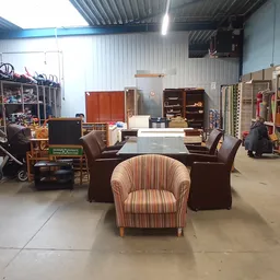 Winkelvloer van kringloopwinkel met meubels, stellingen en diverse tweedehands spullen