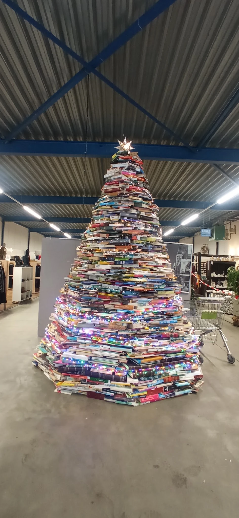 Kerstboom gemaakt van stapels boeken in kringloopwinkel