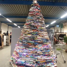 Kerstboom gemaakt van stapels boeken in kringloopwinkel