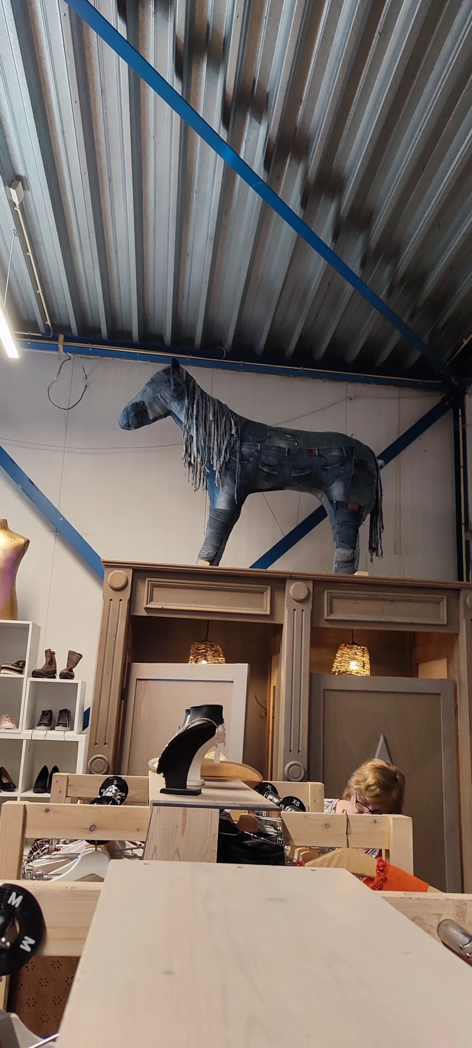 Decoratief paardenstandbeeld van donker materiaal met franjes, opgesteld op houten kastjes met verlichting