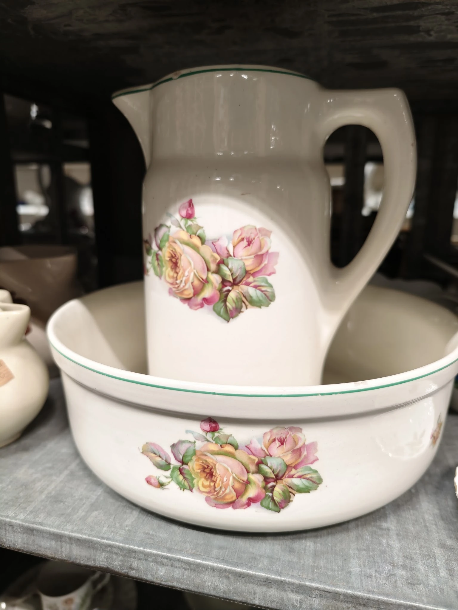 Wit porselein servies met roze bloemenpatroon, bestaande uit kan en kom