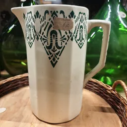 Witte glazen kan met zwart decoratief patroon op houten ondergrond
