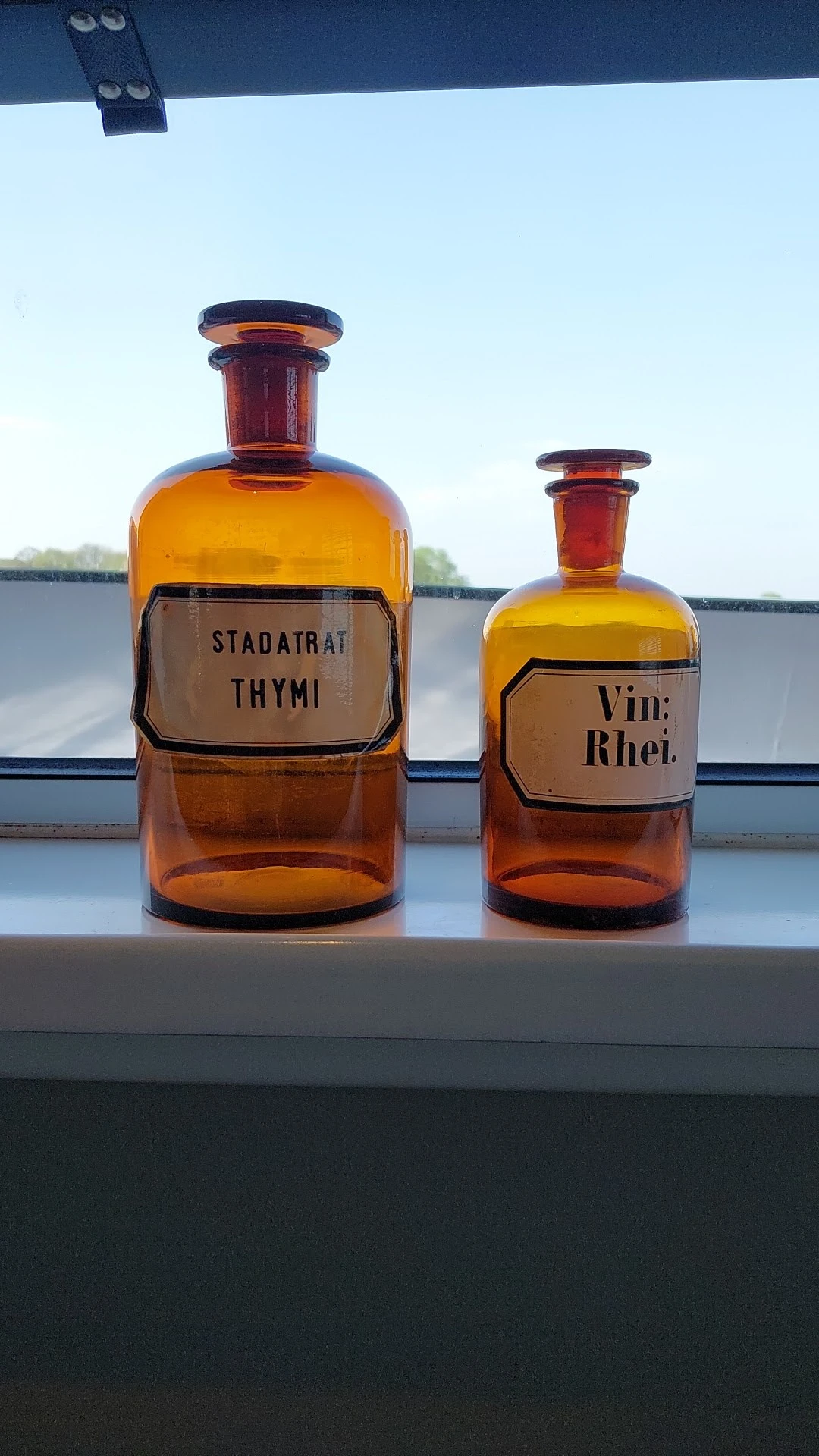 Twee antieke apothekersflesjes met amber glas en labels voor Thymi en Vini Rhei
