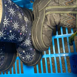 Tweedehands kinderlaarsjes met sterrenpatroon en grijze laarzen op display