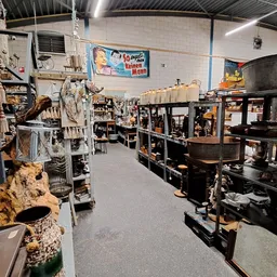 Winkelvloer met stellingen vol huishoudelijke spullen, meubels en gebruikte goederen in een kringloopwinkel