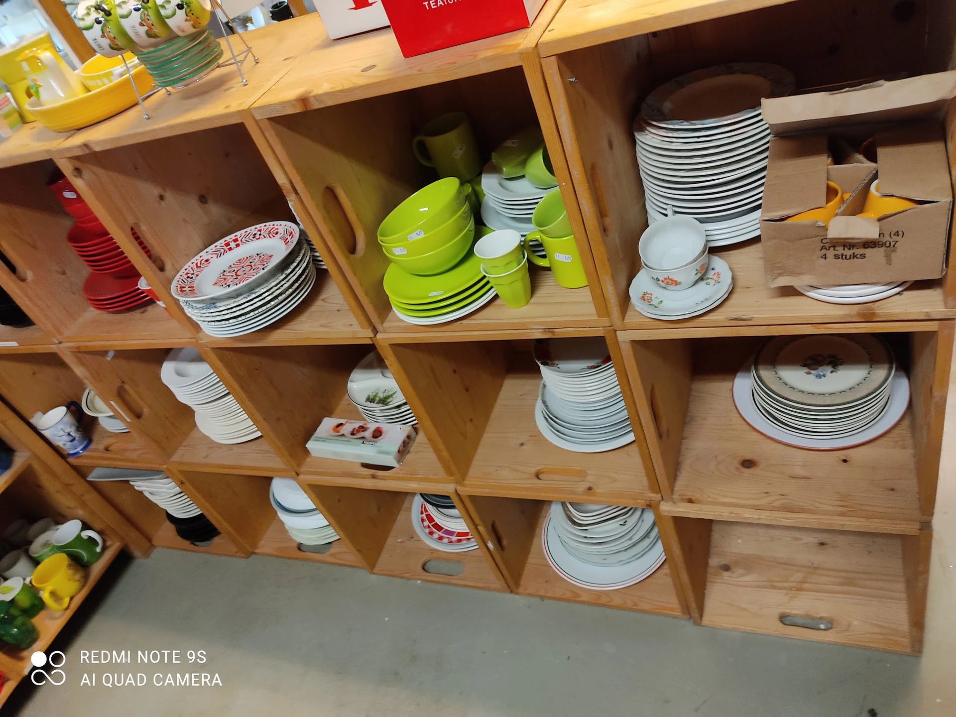 Houten stellingkast met servies, borden, kopjes en keukengerei in diverse kleuren en patronen