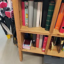 Houten boekenkasten met diverse tweedehands boeken in verschillende kleuren en formaten