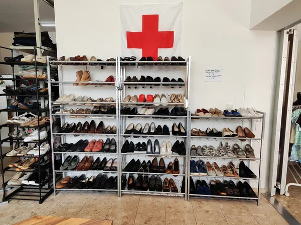 Grote stellingen vol met tweedehands schoenen en laarzen, georganiseerd per kleur en soort