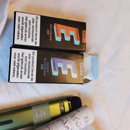 Close-up van twee verpakte producten en een gele pen op papier