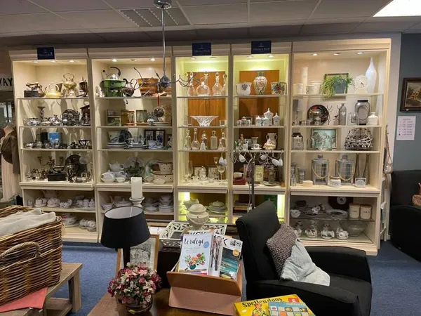 Vitrinekast vol met porselein, serviesgoed en decoratieve objecten in een kringloopwinkel