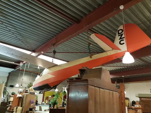 Winkelinterieur met oranje decoratief element aan plafond en hanglampen