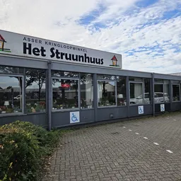 Gevel van kringloopwinkel Het Struunhuus met grote ramen en duidelijke winkelnaam op bord