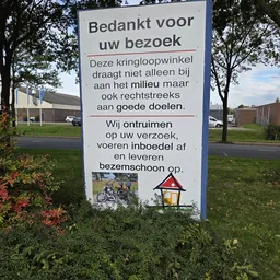 Informatiebord met Nederlandse tekst over bezoek aan kringloopwinkel en gezond gedrag