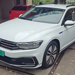 Witte Volkswagen Passat stationwagen geparkeerd buiten, met groene nummerplaat zichtbaar