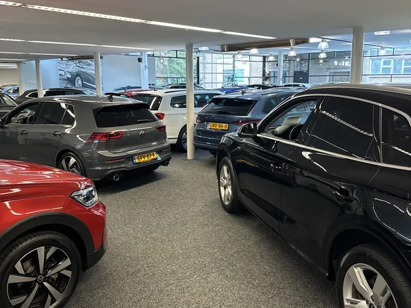 Showroom met meerdere geparkeerde auto's onder fluorescente verlichting