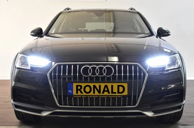 Zwarte Audi-SUV van voren gefotografeerd met LED-koplampen aan en geel nummerplaatje met 'RONALD' erop