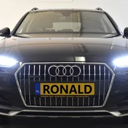 Zwarte Audi-SUV van voren gefotografeerd met LED-koplampen aan en geel nummerplaatje met 'RONALD' erop
