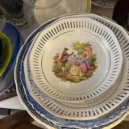Vintage servies met blauwe rand en afbeelding van twee figuren in landelijk tafereel