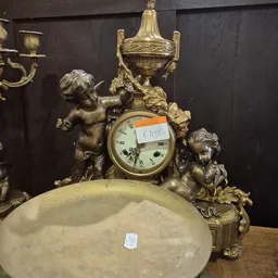 Gouden sierklokkast met cherubijnen en decoratieve elementen, close-up detail