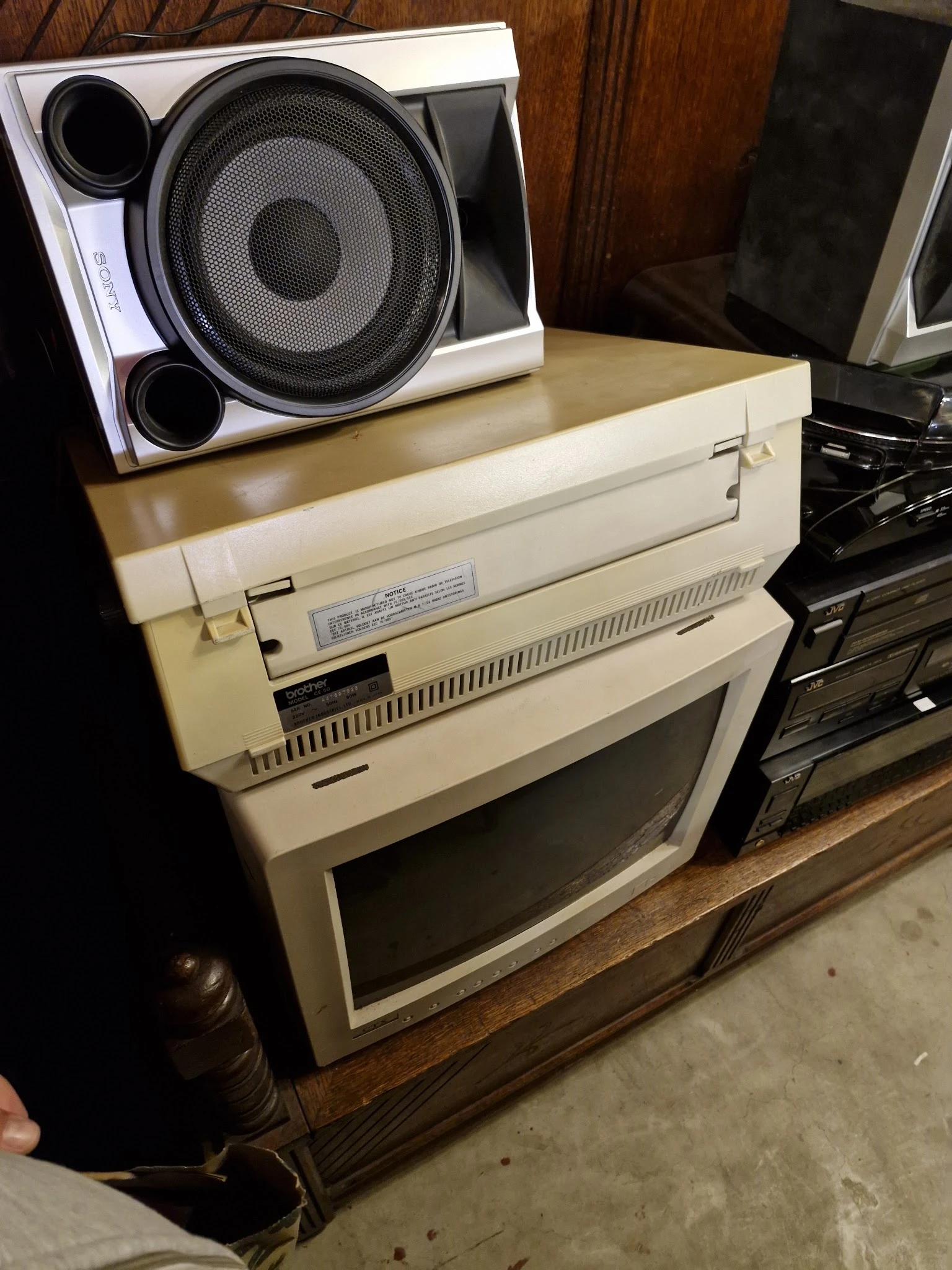 Vintage computer en printer uit de jaren 80/90 op een houten tafel, met een speaker bovenop