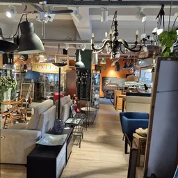 Winkelvloer met stellingen, meubels, lampen en huishoudartikelen in kringloopwinkel
