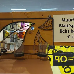 Muurhange blad/spiegel lichthouder in bruin metaal met decoratief bladerenpatroon, prijs 1,50 euro