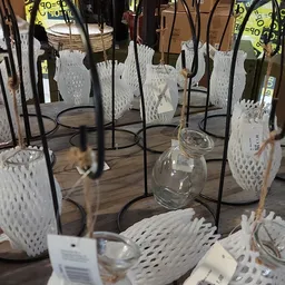 Tafels en stoelen met witte geweven zittingen en zwart metalen frames, uitgestald in de winkel