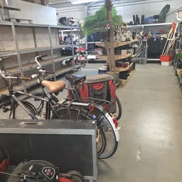 Winkelvloer met fietsen, stellingen, plantenbakken en diverse spullen in kringloopwinkel