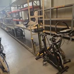 Winkelvloer met fitnessapparatuur en stellingen met opgeslagen goederen