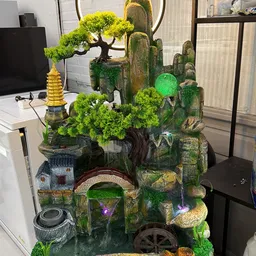 Decoratief diorama met miniatuurbouwwerken, bomen, figuren en verlichting op een donkere achtergrond