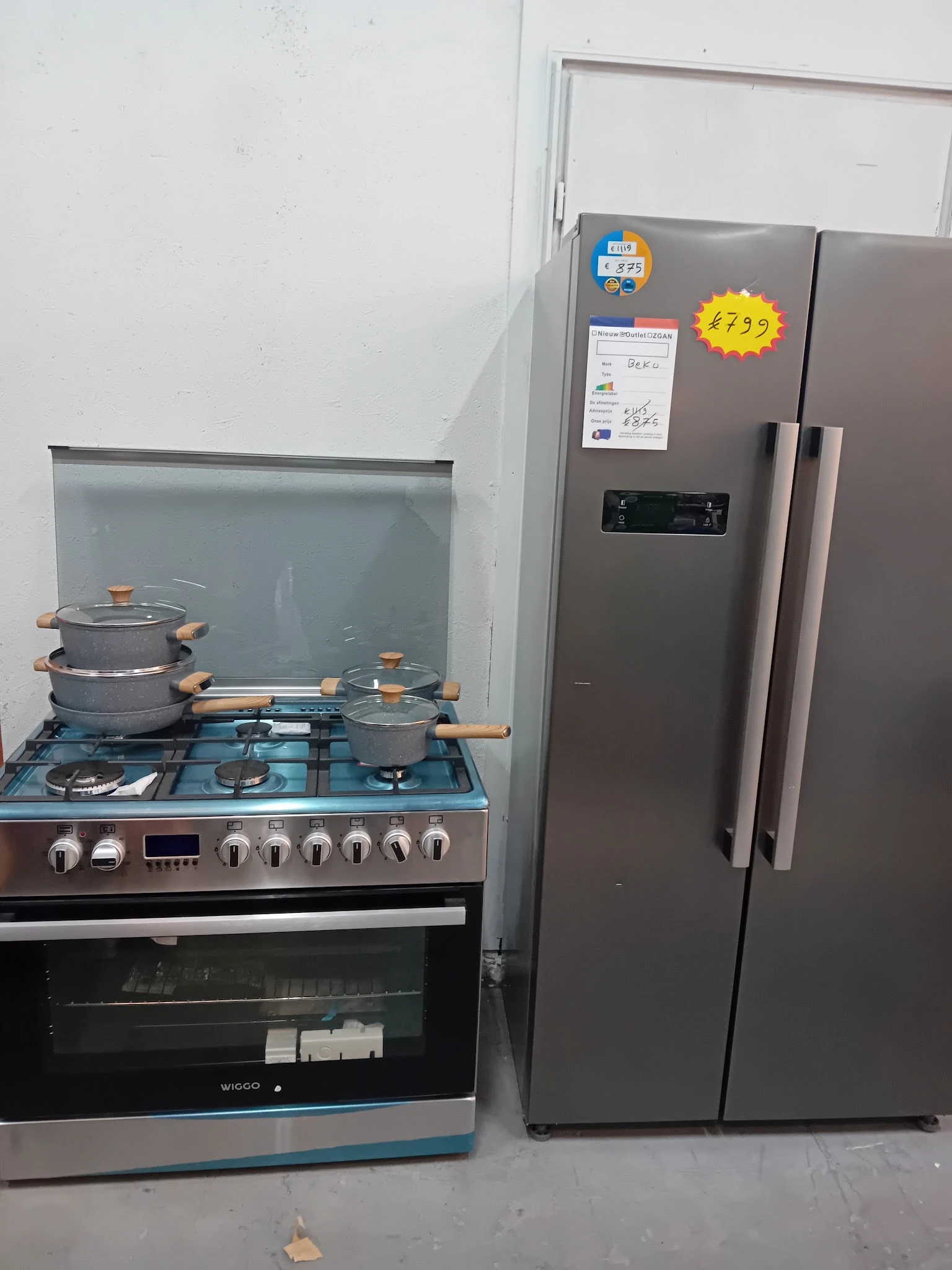 Gaskooktoestel met pannen en een staande koelkast op het uitstallingsoppervlak