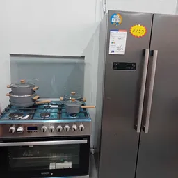 Gaskooktoestel met pannen en een staande koelkast op het uitstallingsoppervlak