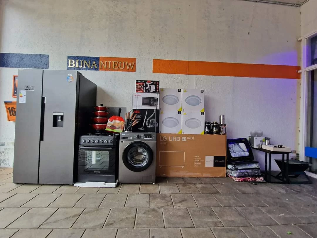 Winkelvloer met uitgestalde huishoudelijke apparaten zoals koelkast, wasmachine, fornuis en televisie
