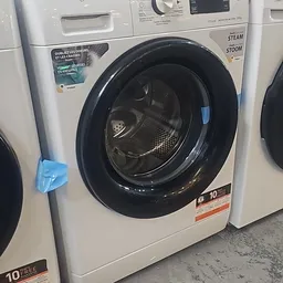 Witte wasmachine met zwarte deur en trommel, in showroommodeling in kringloopwinkel