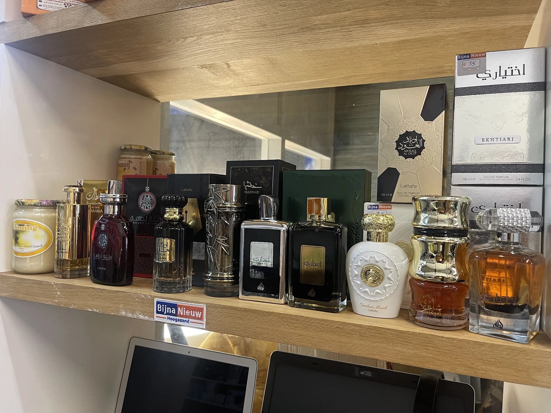 Winkelschap met uitgestalde parfumflessen en cosmeticaproducten in verschillende formaten en kleuren