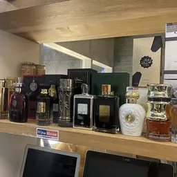 Winkelschap met uitgestalde parfumflessen en cosmeticaproducten in verschillende formaten en kleuren
