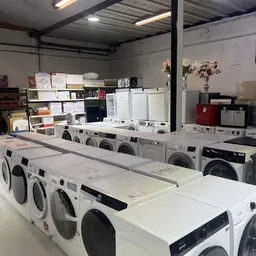 Rijen wasmachines en drogers uitgestald in de kringloopwinkel