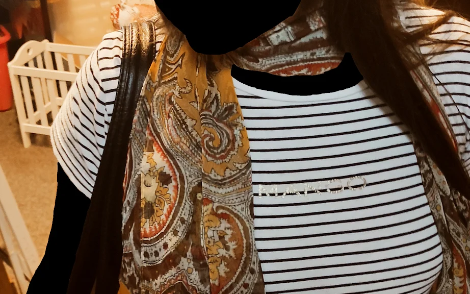 Tweedehands kleding op hangers, waaronder gestreepte en paisley-gemotiveerde kledingstukken