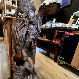 Gedetailleerde houten sculptuur van een vrouwenfiguur met decoratieve elementen