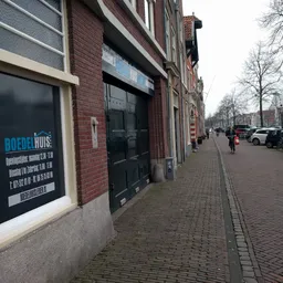 Gevel van kringloopwinkel aan Oude Vest in Leiden met blauwe winkelnaambord en zwarte deuren